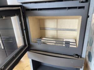 Insert poêle à bois GSTOVE Italy, porte ouverte. Chambre de combustion neuve en vermiculite, avec grille de retenue.